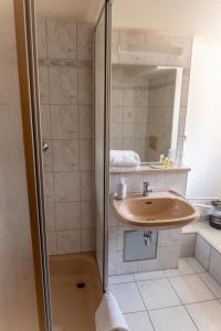 a bathroom with a sink and a shower at Gästehaus am weißen Turm in Rothenburg ob der Tauber