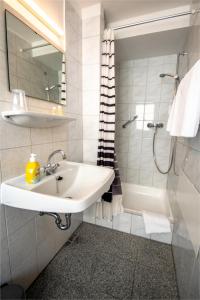 a white bathroom with a sink and a shower at Gästehaus am weißen Turm in Rothenburg ob der Tauber