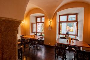 ein Restaurant mit Tischen und Stühlen und Fenstern in der Unterkunft Hotel am weißen Turm in Rothenburg ob der Tauber