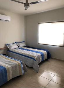 a bedroom with two beds and a window at Terra Viva Villa Campestre in Cuatrociénegas de Carranza