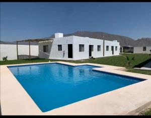 a large blue swimming pool in front of a house at Terra Viva Villa Campestre in Cuatrociénegas de Carranza