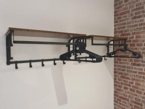 a black metal shelf hanging from a brick wall at The Snug Bourne in Bourne +9 photos