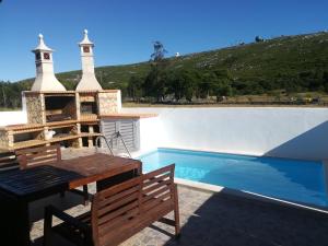 a villa with a swimming pool and a table and bench at Montejunto Villas-Casa do Esquilo in Cadaval