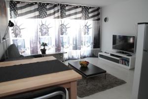a living room with a large window with a television at 1-Zimmer Business Appartement in Worms