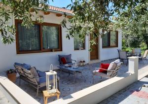 a patio with chairs and a table in front of a house at Anna - Maria Luxury Suite in Skala Rachoniou