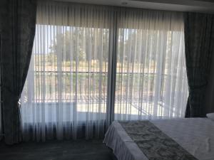 a bedroom with a bed and a large window at Özbek Apart in Ürkmez