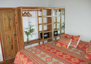 1 dormitorio con 1 cama y armario de madera en Hotel Posada Seremein Roatan, en West Bay