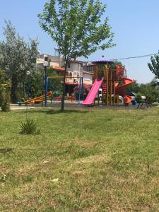 plac zabaw z różową zjeżdżalnią w parku w obiekcie Özbek Apart w mieście Ürkmez