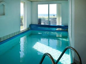 Four-Bedroom Holiday home in Bogense 3 في Skåstrup: مسبح في غرفة مع نافذة كبيرة