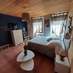 - une chambre avec un lit et un plafond en bois dans l'établissement Les chambres du Presbytère du Val, à Valdeblore