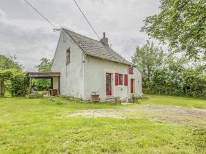 an old white house with red doors and a yard at Country house near Canal du Nivernais in Devay