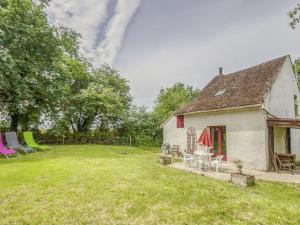 una casa antigua con sillas y un patio en Country house near Canal du Nivernais, en Devay