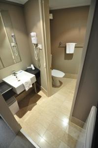 La salle de bains est pourvue d'un lavabo et de toilettes. dans l'établissement Pavilion On Northbourne, à Canberra