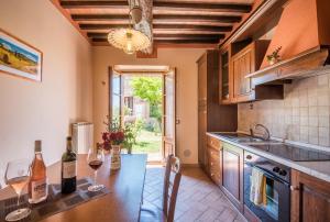 a kitchen with a table with glasses of wine at Agriturismo Oliviera Winery & Hiking in Vagliagli