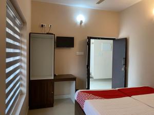 a bedroom with a bed and a mirror and a tv at La Mer Inn in Kozhikode