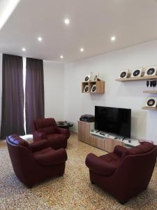 a living room with two chairs and a flat screen tv at Donna Nunzia Home in Noto