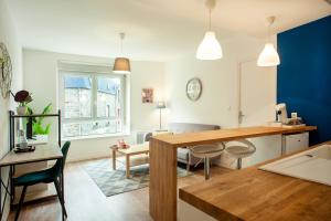 a kitchen and living room with a table and chairs at Les Douces Breizh - Jules Ferry - Proximité Gare SNCF in Saint-Brieuc