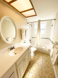 a bathroom with a sink and a toilet and a mirror at Camelot by the Sea in St. Pete Beach