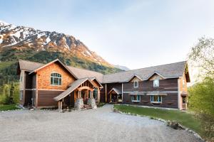 una grande casa in legno con una montagna sullo sfondo di Inn at Tern Lake a Moose Pass