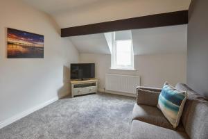 a living room with a couch and a television at Host & Stay - Emerald Hideaway in Saltburn-by-the-Sea