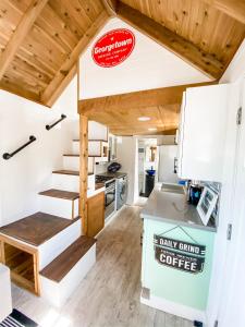 a tiny house with a kitchen and stairs at Pacific Dunes Resort in Copalis Beach