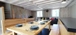 a dining room with a long table with blue dishes on it at Les perles vertes in Arlempdes