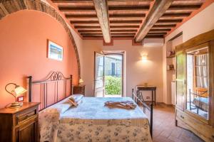 - une chambre avec un lit et une grande fenêtre dans l'établissement Agriturismo Oliviera Winery & Hiking, à Vagliagli