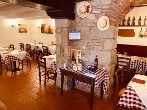 a restaurant with tables and chairs and a stone wall at Antica Locanda La Posta in Gaggio Montano