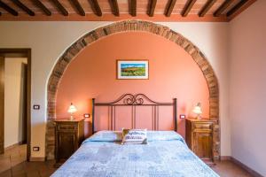 VagliagliにあるAgriturismo Oliviera Winery & Hikingのアーチ型の大型ベッドが備わるベッドルーム1室が備わります。