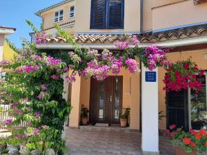a house with flowers in front of it at Apartments Rina in Rovinj