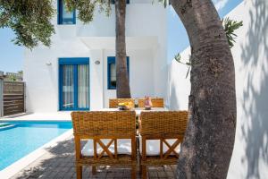 an outdoor table and chairs next to a swimming pool at Anna Plakias Apartments in Plakias