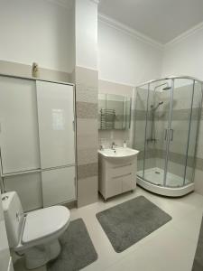 een badkamer met een toilet, een douche en een wastafel bij Modern Apartment in Lviv