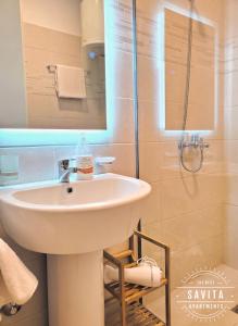 a bathroom with a sink and a shower at Gjiri i Lalzit - Savita Apartments - Kompleksi Turistik Lura 3 in Mullini i Danit +70 photos