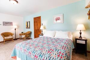 a bedroom with a bed and two chairs at Inn at Tern Lake in Moose Pass