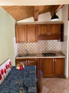 una cocina con mesa y una cocina con armarios de madera. en CityGuestHouse Catanzaro, en Catanzaro