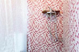 ein Badezimmer mit rot gefliester Wand und Dusche in der Unterkunft Casa Boutique Margarita in Peñíscola + 22 Fotos