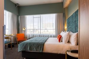 Säng eller sängar i ett rum på The Muse Christchurch Art Hotel