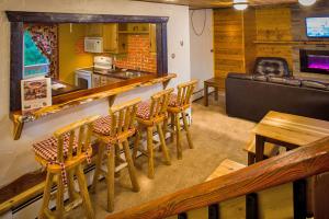 a restaurant with a bar and some wooden chairs at Curriers Lakeview Lodge in Rice Lake