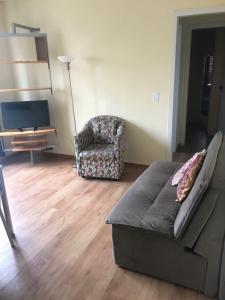 a living room with a couch and a chair at POA zona norte - melhor opção - completíssimo in Porto Alegre