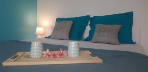 - un lit avec des oreillers bleus et 2 vases dans l'établissement Vue Mer & Accès Direct à la Plage avec Magnifique Piscine, à Saint-François
