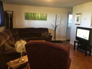 a living room with a couch and a television at BeachView Apartment in Port Hood