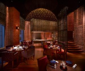 a restaurant with tables and chairs and a kitchen at Grand Hyatt Shenzhen in Shenzhen