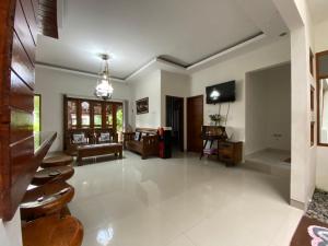 ein Wohnzimmer mit einem Sofa und einem TV in der Unterkunft Rengganis Homestay in Yogyakarta