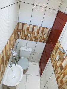 a small bathroom with a toilet and a sink at Casa em Gravata mobiliada in Gravatá