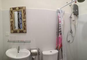 a bathroom with a toilet and a sink and a mirror at KC Beachfront in Marang +26 photos