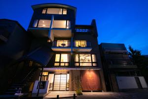 un edificio alto con muchas ventanas por la noche en Riverte Kyoto Kamogawa, en Kioto