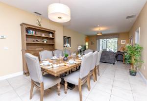 Un comedor con mesa y sillas de madera. en Newly Remodeled 1 story - 5 Bed 5 Bath with Pvt Pool Spa And Game Room, en Kissimmee