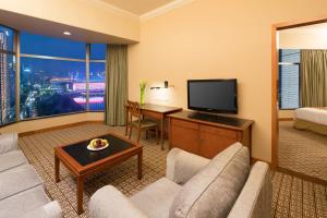 a living room with a couch and a flat screen tv at Ramada by Wyndham Pearl Guangzhou-Canton Fair Free Shuttle Bus in Guangzhou