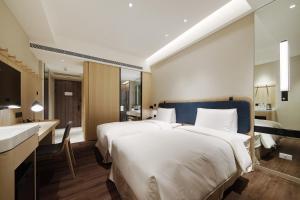Ένα ή περισσότερα κρεβάτια σε δωμάτιο στο Jasper Young Hotel Banqiao