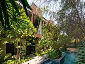 a villa with a swimming pool in a garden at Cherlock hotel in Chiang Mai